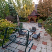 Клумбы, дорожки, кусты и качели для отдыха